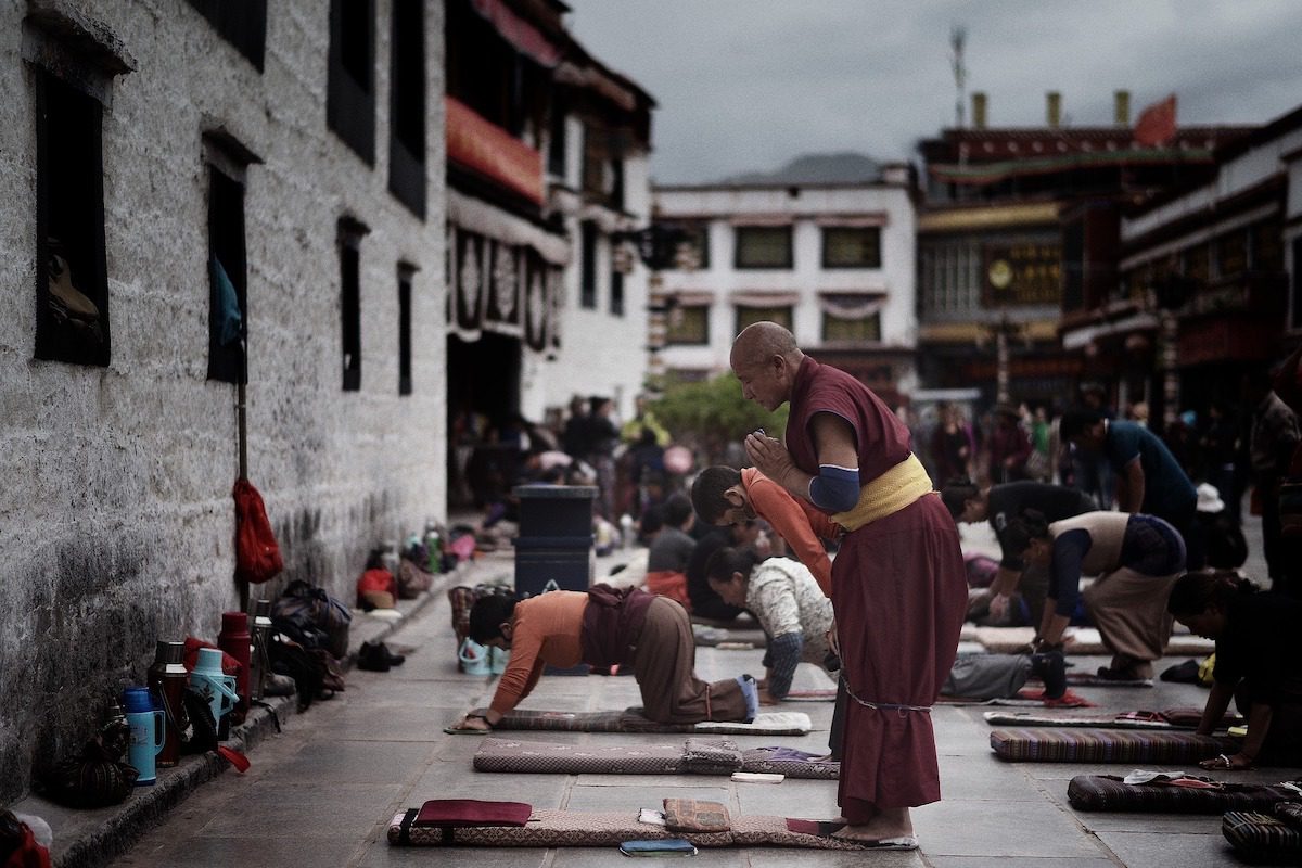 Munk der beder på gaden i Tibet